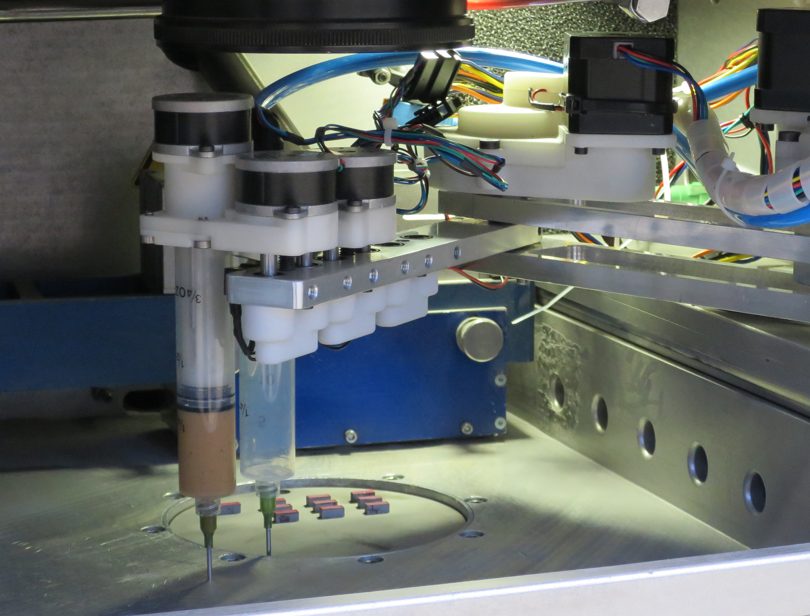 Multimaterialfertigung: Dispenser und Saugmodul innerhalb der Baukammer einer Laserstrahlschmelzanlage.